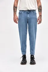 Jean de corte mom fit en color azul medio con acabado marmolado, confeccionado en denim resistente. Presenta cierre frontal con botón, bolsillos laterales y traseros, y un ajuste ligeramente holgado en las piernas con terminación recta.