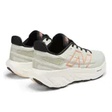 Championes de running New Balance Fresh Foam X 1080 V13 para mujer. Capellada de malla y sintético color crema con logo "N" delineado en naranja. Entresuela Fresh Foam X blanca y suela de goma negra.