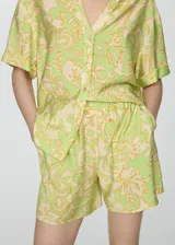 Short de corte recto y diseño fluido, con cintura elástica y bolsillos laterales. Presenta un estampado botánico en tonos verde lima y crema.