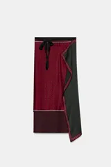 Pareo tipo pañuelo de viscosa con diseño cruzado y cierre mediante lazada en la cintura. Presenta un estampado de lunares pequeños sobre fondo bordó y un panel lateral en color verde oscuro con microestampado, ambos con bordes definidos.