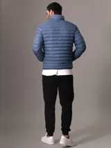 Campera acolchada azul con cuello alto, cierre frontal con cremallera y bolsillos laterales.