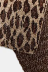 Bufanda de punto rectangular con diseño de estampado animal en tonos marrones y beige, confeccionada en mezcla de tejidos con lana.