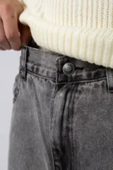 Jean de corte mom fit en color gris lavado, confeccionado en denim resistente, con diseño de tiro medio y ajuste holgado en las piernas.