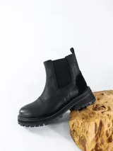 Bota Chelsea de cuero negro con elásticos laterales, suela track y tirador trasero.
