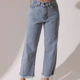 Pantalón jean celeste de corte recto con terminación desflecada.
