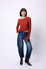 Top de manga larga con diseño de hombros descubiertos y estampado de letras repetidas en color rojo sobre fondo marrón.