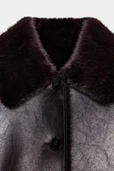 Cazadora reversible de corte recto, con cuello solapa, manga larga y cierre frontal con botones. Presenta un acabado efecto piel con textura y bolsillos delanteros de doble vivo.