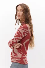 Polera de tejido de punto con diseño vanizado que combina tonos tierra y crema en un patrón abstracto de líneas onduladas. Presenta cuello alto, mangas largas y un ajuste entallado al cuerpo.