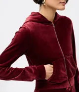 Saco abierto de plush color bordó, con cierre frontal, capucha y bolsillos funcionales. Presenta una textura suave y confortable, ideal para abrigo.