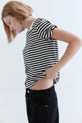 Remera de corte recto en punto suave de algodón con cuello redondo ribeteado y hombros ligeramente caídos. Diseño a rayas horizontales blancas y negras.