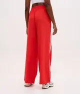 Pantalón deportivo Get Over de color rojo con cintura elástica, bolsillos laterales y doble franja blanca en los laterales.