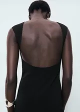 Vestido midi de corte recto y diseño minimalista, confeccionado en tejido elástico. Presenta cuello barco, tirantes anchos, espalda descubierta y una abertura posterior en el bajo.