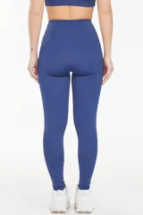 Calza deportiva larga de tiro alto, color azul, con bolsillos laterales funcionales y diseño anatómico de ajuste compresivo.