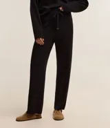 Pantalón wide leg de punto con textura acanalada, cintura elástica con lazo ajustable y detalles metalizados, y frisos verticales a lo largo de la pierna.