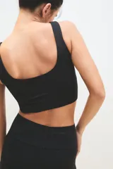 Top deportivo de escote redondo y espalda estilo nadador, confeccionado en tejido técnico elástico. Presenta un diseño ajustado al cuerpo con pretina ancha para mayor soporte.