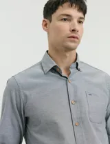 Camisa de manga larga en color azul grisáceo, con cuello button-down, bolsillo frontal y botones de madera.
