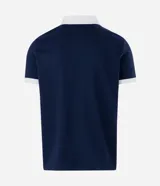 Polo de manga corta color azul marino con cuello y bordes de mangas en color blanco. Presenta cierre frontal parcial y escudo bordado en el pecho.
