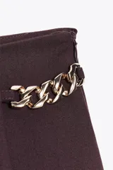 Bermuda de tiro alto color negro, con diseño de tablas frontales y detalle de eslabones metálicos dorados en la cintura. Cuenta con cierre lateral oculto.