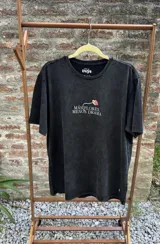 Remera blanca de manga corta, confeccionada en algodón premium, con estampa central de flores coloridas y la frase 'Más flores, menos drama'.