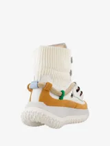 Bota hasta el tobillo color blanco con detalles en marrón y suela track.