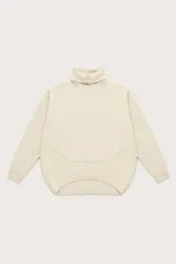 Polera de cuello alto con diseño oversize, manga larga y dobladillo asimétrico con corte redondeado en la parte frontal.