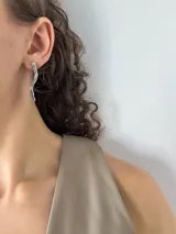 Aros colgantes plateados con forma de serpiente gruesa.