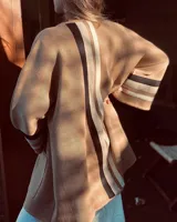 Saco color beige de tejido fino en lana con detalles en cintas tejidas en las mangas y cierre con presillas tipo Montgomery.