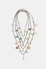 Pack de cuatro collares de abalorios metalizados en diferentes longitudes, decorados con dijes colgantes de conchas naturales y caracoles marinos.