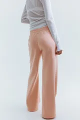 Pantalón deportivo de felpa color rosado, con bajo levemente acampanado, cintura estándar con elástico revestido y cordón ajustable.