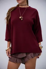 Sweater de punto color bordó, de manga larga y cuello redondo.