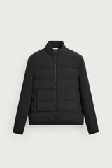 Campera acolchada negra de cuello alto, con cuerpo matelasseado y mangas lisas de tejido elástico. Cuenta con bolsillos en las caderas, cierre frontal por cremallera y bajo con elástico.