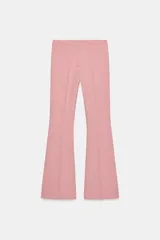 Pantalón de vestir color rosado, tiro bajo, con corte acampanado (flare) y costuras laterales marcadas. Cierre frontal con botón interior y gancho.