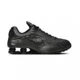 Championes Nike Shox R4 de diseño técnico en color negro total. Presentan la icónica tecnología de amortiguación Shox en el talón, con una estructura de columnas que proporciona soporte y respuesta. El exterior combina cuero sintético con paneles perforados para mayor ventilación y un acabado elegante.