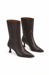 Botas de caña media en color chocolate de cuero, con punta fina y taco kitten. La caña recta aporta estructura y el diseño combina una estética moderna y minimalista.