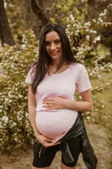 Remera de algodón elastizado color rosa pastel, diseñada con un corte especial para embarazo y lactancia, con apertura frontal discreta. Presenta cuello redondo y mangas cortas.