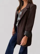 Blazer sastrero color marrón chocolate, de corte clásico con hombreras, botones frontales y bolsillos funcionales. Cuenta con forrería interna y mangas con vuelta.