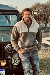 Buzo de polar con cierre a mitad del pecho, color verde y blanco.