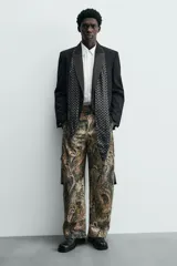 Zueco destalonado de cuero negro con hebilla metálica ajustable en el empeine, plantilla de cuero y suela plana con pequeño tacón.