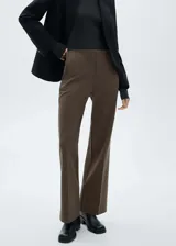 Pantalon de vestir de tiro medio con corte flare y diseño largo. Cuenta con dos bolsillos laterales y cierre frontal con cremallera, botón y ganchos ocultos bajo tapeta.