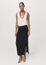 Falda midi tiro medio de color negro, con diseño cruzado y tajo delantero.