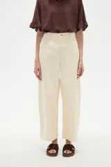 Pantalon de jean estilo barrel, color natural, de tiro medio con bolsillos laterales y cierre frontal.