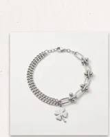 Pulsera de plata con diseño de cadena múltiple y dije colgante en forma de trébol de cuatro hojas.