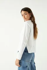 Remera manga larga color beige, con cuello bote y corte recto a la altura de la cadera.