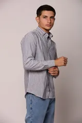 Camisa de manga larga con estampado de rayas verticales, cuello abotonado y cierre frontal con botones.