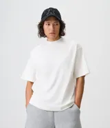 Remera blanca de algodón con corte boxy, cuello mock neck y mangas cortas.