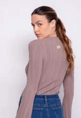 Polera roja de tejido de punto acanalado, con cuello alto y mangas largas acampanadas.