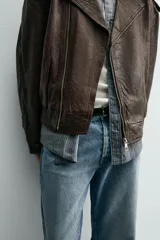 Pantalón de jean con corte recto desde la cadera hasta el tobillo, de tiro medio y ajuste holgado. Presenta diseño de cinco bolsillos, cierre frontal con cremallera y botón, y acabado con efecto lavado.