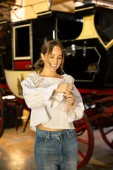 Blusa de algodón con estampado a cuadros vichy en tonos beige y blanco. Presenta un diseño con volados en el escote, mangas largas amplias y puños con volados.