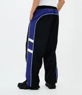 Pantalón deportivo de corte recto confeccionado en microfibra de poliamida, color negro con paneles laterales en color violeta y detalles en blanco. Cuenta con cintura elástica con cordón ajustable.