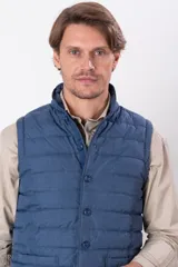 Chaleco azul de nylon con corte tipo vestir y relleno de guata.